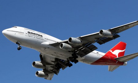 Boeing 747 de Qantas transportando un motor bajo su ala.