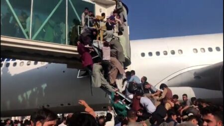 Afganos tratando de abordar un avión en el aeropuerto de Kabul.