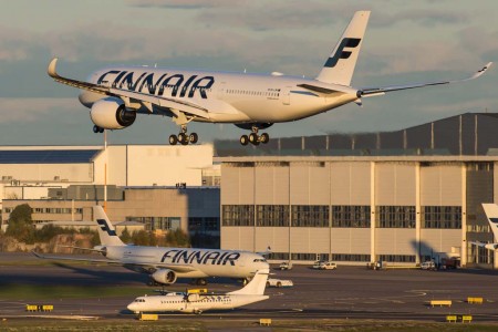 Un A350 de Finnair aterriza en Helsinki mientras un ATR 72 y un A330 de Finnair esperan su turno para despegar.