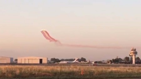 La Patrulla Águila sobrevuela el aeropuerto de Sevilla instantes antes del aterrizaje del Solar Impulse 2. El Il-76 que se puede ver en la plataforma había trasladado al aeropuerto los diversos equipos necesarios para atender al Solar Impulse tras su llegada y para su mantenimiento tras el vuelo.