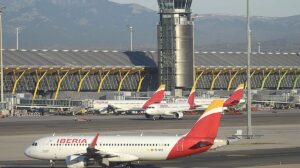 Aviones en la plataforma de la T4 del aeropuerto Madrid - Barajas, con la torre auxiliar para rodaje al fondo.