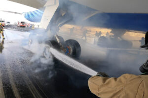 Los bomberos enfriando las ruedas y frenos del Boeing 777-9 tras la prueba de frenado máximo.