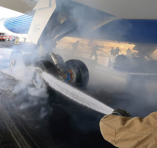 Los bomberos enfriando las ruedas y frenos del Boeing 777-9 tras la prueba de frenado máximo.