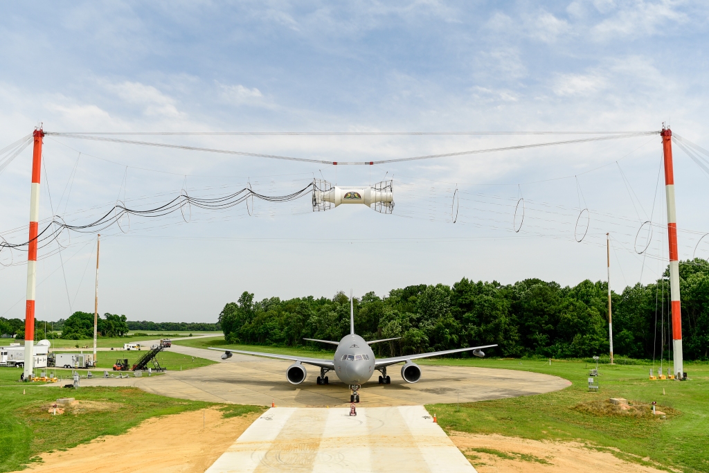 El Boeing KC-46 durante las pruebas de compatibilidad electromagnética en Patuxent River. Sobre él la bobina y transformador encargada de generar los pulsos electromagnéticos.