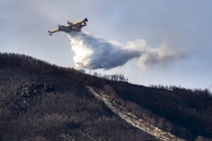 Canadair CL-215T del Ejército del Aire haciendo una descarga de agua en un incendio.