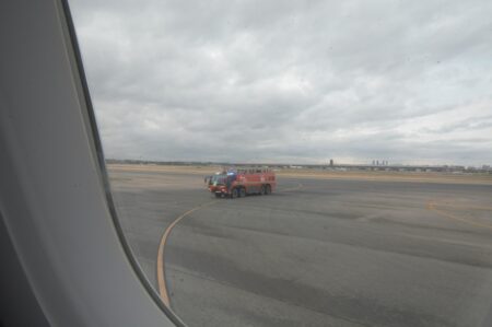 Los bomberos esperando para hacer el arco de agua en Barajas.