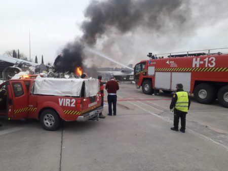 Los bomberos del aeropuerto apagando el pequeño incendio de los restos del Airbus A340-300 de Iberia.