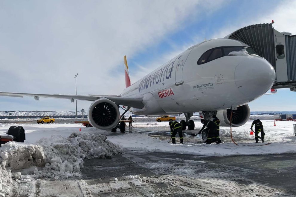 Retirada de nieve junto a un Airbus A320 de Iberia en la T4 del aeropuerto de Madrid Barajas.