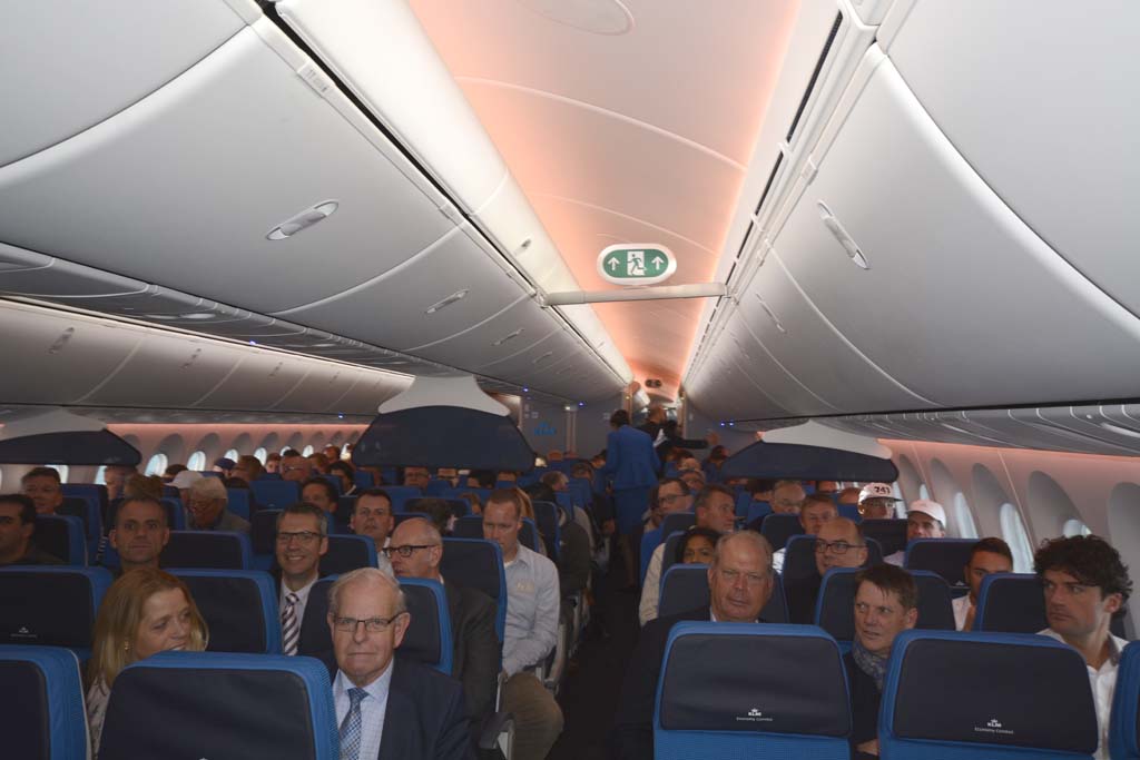 Pasajeros del vuelo de presentación del Boeing 787 de KLM. Economy Confort y Economy van separadas con unas pequeñas pantallas colgantes.