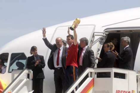 Iker Casillas, junto a Vicente del Bosque y Ángel María Villar saluda desde la puerta del A340 de Iberia, copa del mundo en alto, a la llegada de La Roja como campeona del mundo de fútbol.