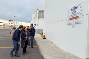 Margarita Robles junto a la placa que recuerda los aviones que se han usdo en la AGA desde 1943.