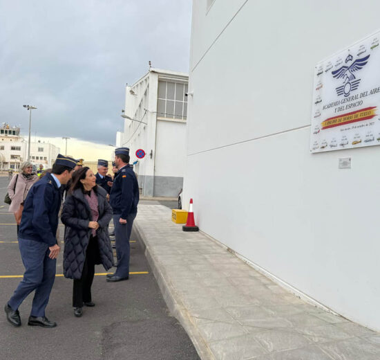 Margarita Robles junto a la placa que recuerda los aviones que se han usdo en la AGA desde 1943.