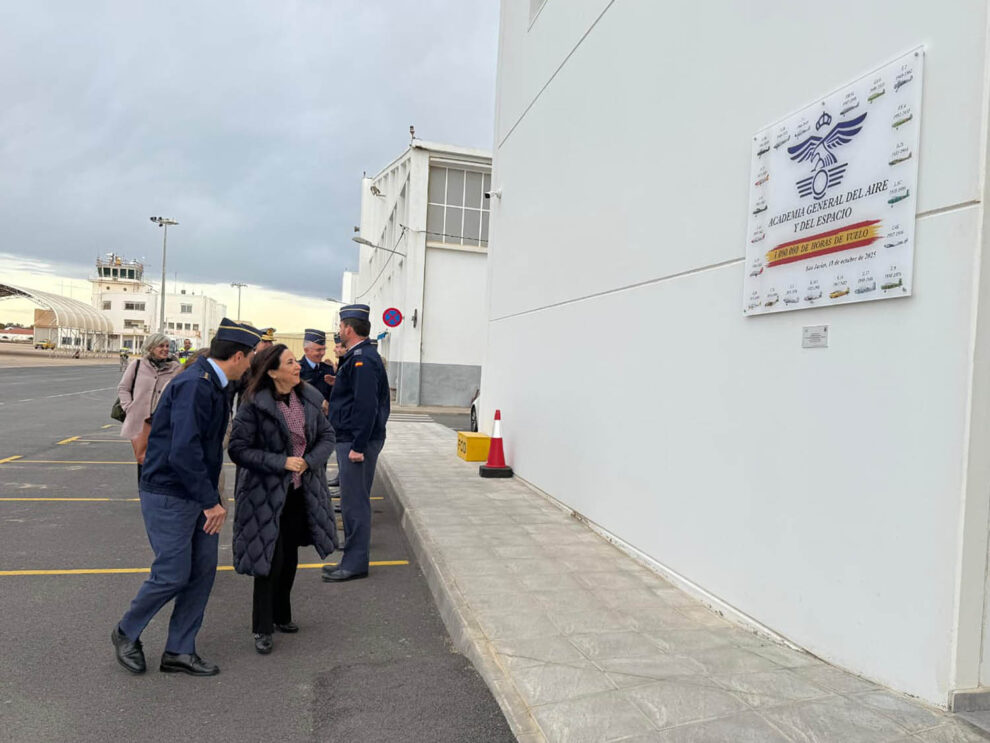 Margarita Robles junto a la placa que recuerda los aviones que se han usdo en la AGA desde 1943.