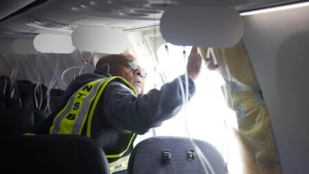 Un investigador del NTSB lleva a cabo una primera inspección de los anclajes de la sección del fuselaje del Boeing 737-9 de Alaska Airlines.
