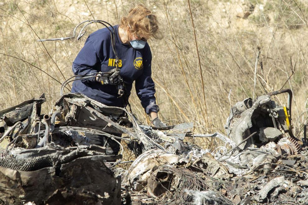 Un miembro del equipo de investigación del NTSB examina los restos del helicóptero en el que falleció Kobe Bryant con su hija y otros seis acompañantes y el piloto.