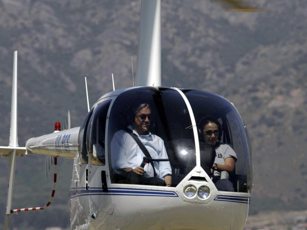 Sebastián Piñera a los mandos de un R44 similar al accidentado.