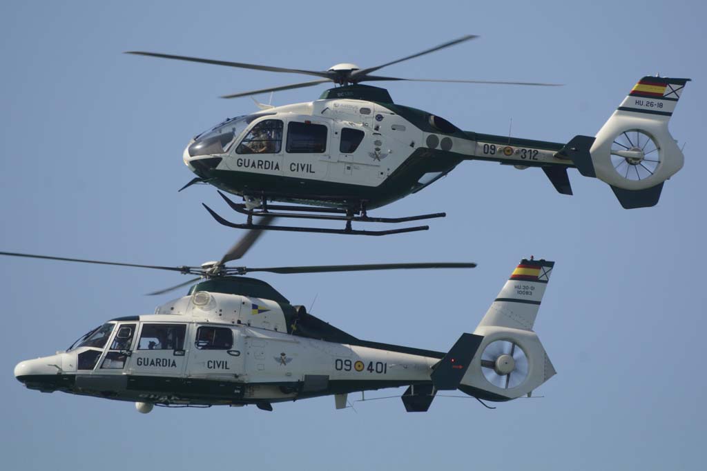 El EC135 y el AS365 de la Guardia Civil durante su pasada sobre la playa de Rota.