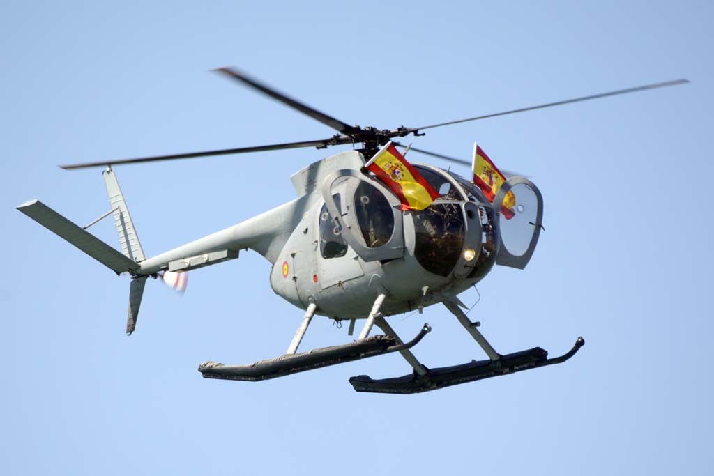Como final de su actuación, los pilotos de uno de los Hughes 500 sacaron sendas banderas españolas por las puertas de su helicóptero.