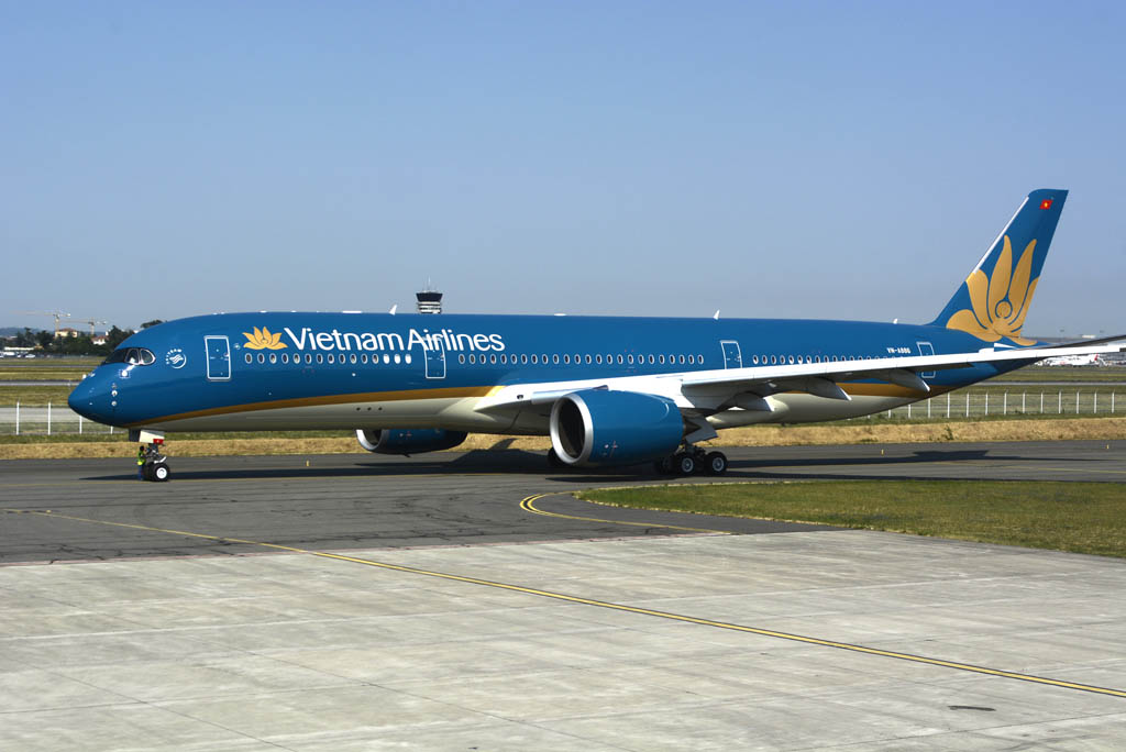 El Airbus A350 luce la nueva decoración de Vietnam Airlines, una variación de la anterior, ahora con una banda dorada en arco en lugar de una blanca recta, y con la panza en crema en gris oscuro.